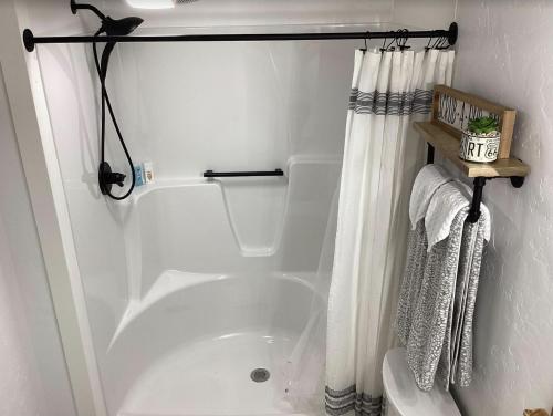 a bathroom with a tub and a shower curtain at Farmhouse of Blessings in Dundee