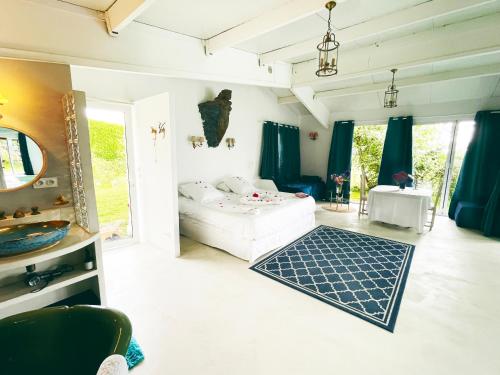 a living room with a white couch and a mirror at Suite Loft de la Sirène Grande piscine privée in Marais-Vernier