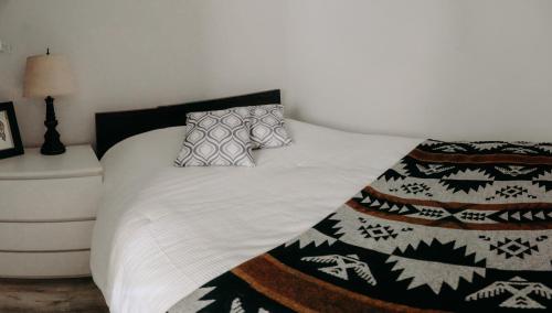 a bed with a black and white blanket and pillows at Small Private Studio at Kitsilano Beach in Vancouver