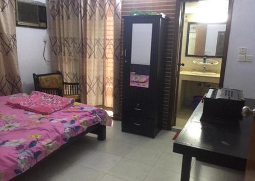 1 dormitorio con cama, lavabo y espejo en Rainbow Guest House, en Dhaka