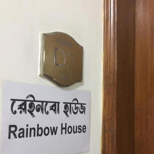 un orologio su un muro accanto a una casa del bagno di Rainbow Guest House a Dhaka