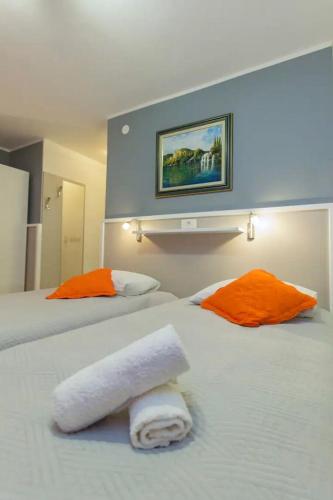 a hotel room with two beds with towels on them at Apartments and Rooms Villa Marija in Skradin