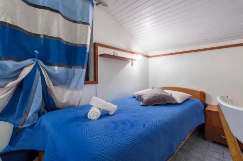 a bedroom with a blue bed with towels on it at Apartments and Rooms Villa Marija in Skradin