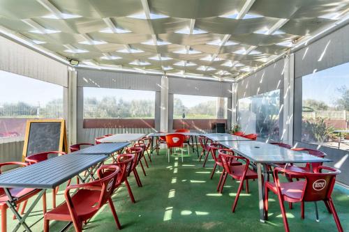 una fila di tavoli e sedie in una stanza con finestre di Villa Paradis Pêra - Casa completa para férias a Pêra