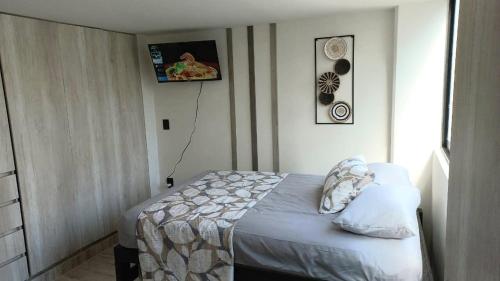 a bedroom with a bed and a tv on the wall at Grand Depa Bellomar in Acapulco
