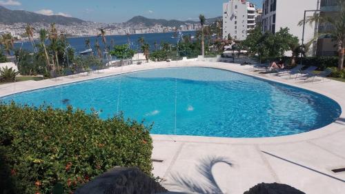 a large swimming pool with a view of the water at Grand Depa Bellomar in Acapulco