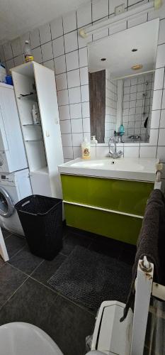 baño con bañera verde y blanca y lavamanos en Entire house in Weert en Weert