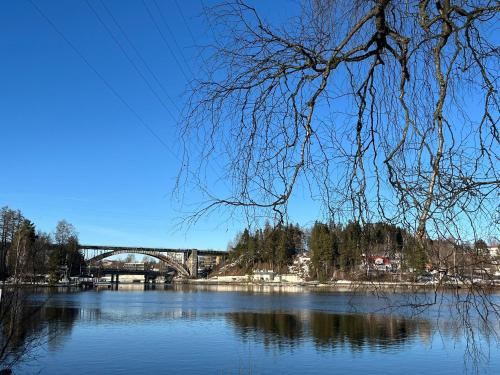 a bridge over a river with a bridge in the background at Viihtyisä ja valoisa yksiö keskustan läheisyydessä in Heinola