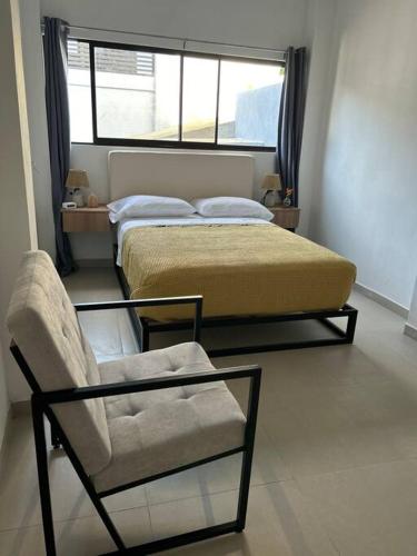 1 dormitorio con 1 cama, 1 silla y 1 ventana en Caribbean View - Roosevelt #2, en Puerto Limón