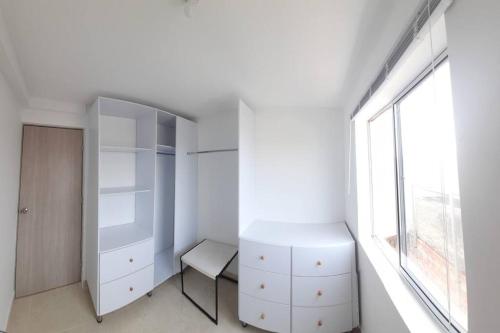 a bedroom with a white cabinet and a window at Confort y descanso cerca al mar in Cartagena de Indias