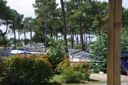 a view of a park with trees and a boat at Mobilhome Ba662 3chSiblu Bonne Anse La Palmyre in Les Mathes