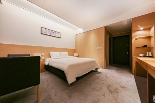 a hotel room with a bed and a desk at Sejong City Osong Hotel in Cheongju