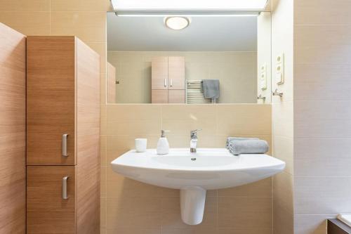 y baño con lavabo blanco y espejo. en Urban Haven: Blissful Living in Central Bratislava, en Bratislava