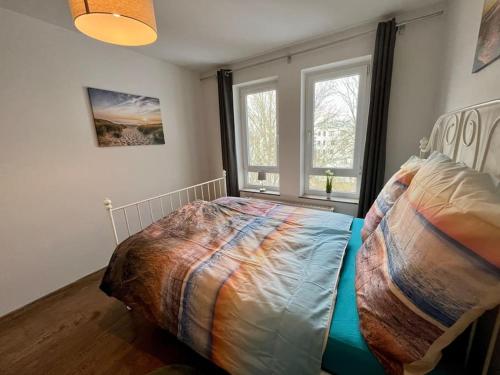 ein Schlafzimmer mit einem Bett in einem Zimmer mit zwei Fenstern in der Unterkunft Am Puls der Stadt, inkl TG-Stellplatz & Balkon in Leipzig