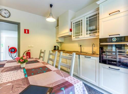 a kitchen with a table and a kitchen with white cabinets at Spacious castle with garden in Aywaille in Aywaille