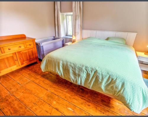 a bedroom with a bed and a wooden floor at Spacious castle with garden in Aywaille in Aywaille