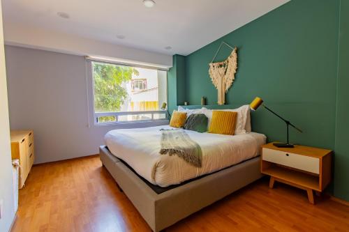 Un dormitorio con una cama grande y una ventana en Capitalia - Apartments - Anzures, en Ciudad de México