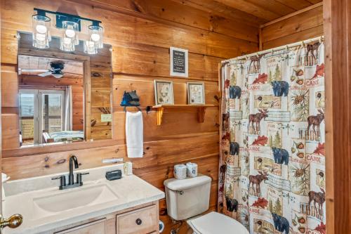 een badkamer met een toilet, een wastafel en een spiegel bij Scenic Ridge in Gatlinburg