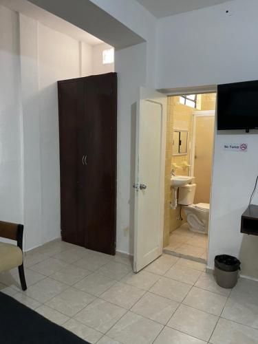 a room with a door and a bathroom at Hotel Cupules in Mérida