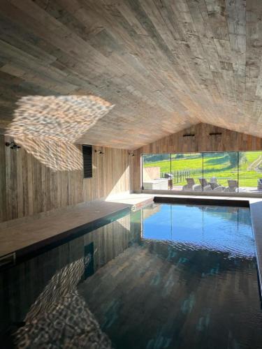 a swimming pool in a building with a large window at The Carthouse, South Courtyard in Ledbury