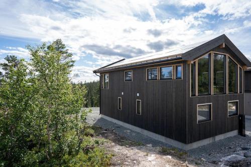a brown house with windows on the side of it at New, modern, cosy hut close to Norefjell Ski & Spa in Surteberg