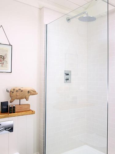 a shower with a glass door in a bathroom at The Piggery, South Courtyard in Ledbury