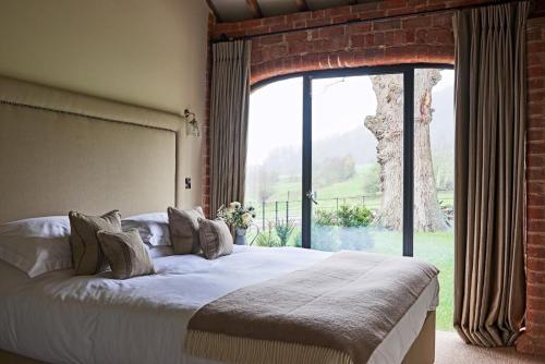 um quarto com uma cama grande e uma janela grande em The Stables em Ledbury