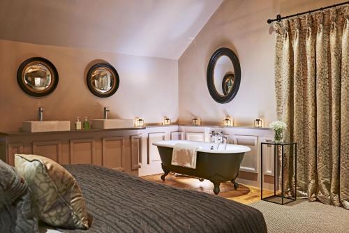 a bedroom with a bath tub and a sink at The Stables in Ledbury