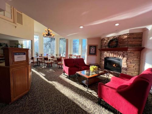 a living room with red furniture and a fireplace at Best Western Country Lane Inn in Mendenhaven
