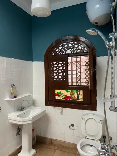 a bathroom with a sink and a toilet and a window at pyramids view Guest villa in Al Mazghūnah