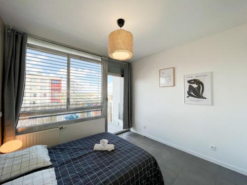 sypialnia z łóżkiem i dużym oknem w obiekcie Suite Helena w mieście Villeurbanne