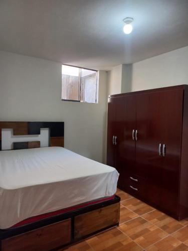 sypialnia z łóżkiem i dużą drewnianą szafką w obiekcie Casa de Santitos w mieście Puerto Chicama