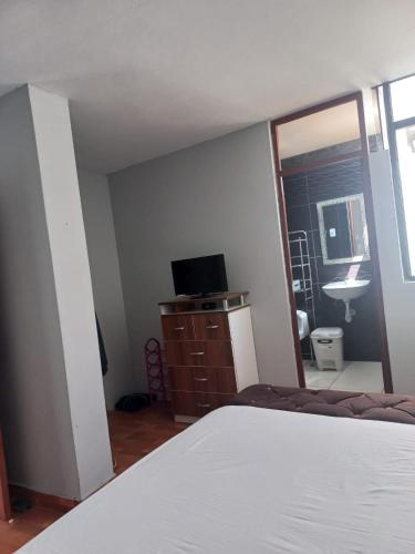 sypialnia z łóżkiem, umywalką i lustrem w obiekcie Casa de Santitos w mieście Puerto Chicama