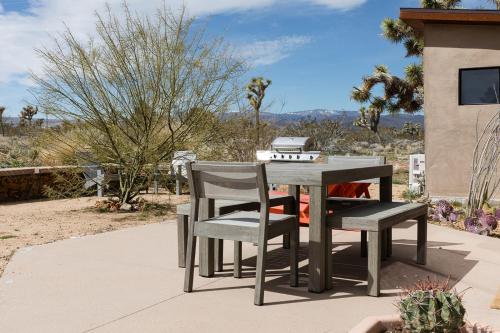a table and chairs on a patio at Joshua Tree Modern Cabin- Goat Mountain Rising in Landers