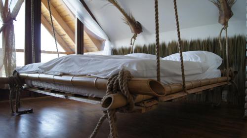a swing bed with white sheets and pillows on it at Rybacka Osada in Piecki
