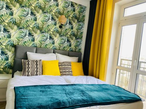 a bedroom with a bed with a green and yellow wall at Olivia Apartments - Słoneczny apartament w centrum Warszawy, Plac Unii Lubelskiej, Łazienki Królewskie, Pole Mokotowskie - 24h check-in in Warsaw