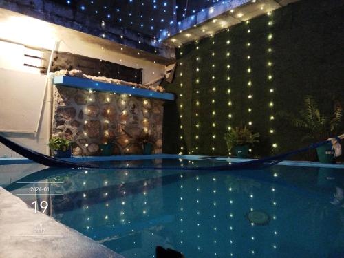 a swimming pool with lights on the side of a building at Villa Akbal with private pool in Bacalar