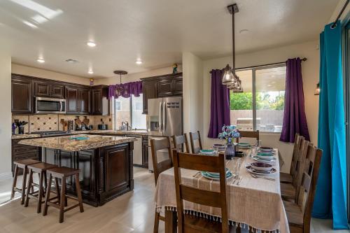 a kitchen with a table and chairs and a kitchen with purple curtains at Coachella Play - 6BR Multi-Gen Fun Zone and Retreat with free heated pool in Indio