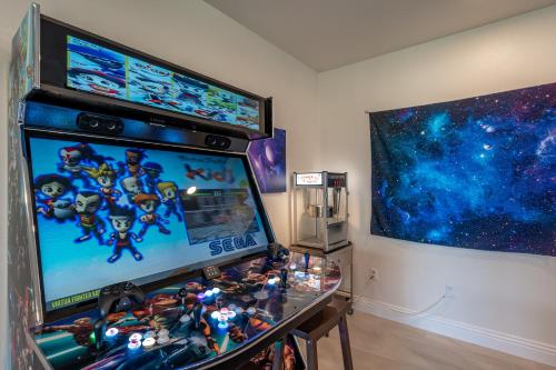 a room with a video game machine with toys on it at Coachella Play - 6BR Multi-Gen Fun Zone and Retreat with free heated pool in Indio