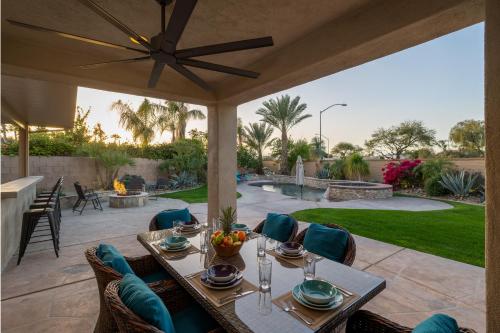 a patio with a table and chairs and a garden at Coachella Play - 6BR Multi-Gen Fun Zone and Retreat with free heated pool in Indio