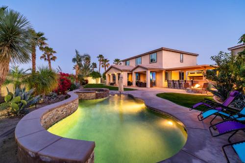 a house with a swimming pool in front of a house at Coachella Play - 6BR Multi-Gen Fun Zone and Retreat with free heated pool in Indio