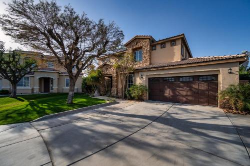 a house with a driveway and a garage at Coachella Play - 6BR Multi-Gen Fun Zone and Retreat with free heated pool in Indio