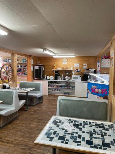 a room with tables and chairs and a kitchen at Bear Country Inn and Suites in Mountain View