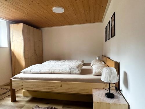 a bed in a bedroom with a wooden ceiling at Ferienwohnung Becker in Dalaas