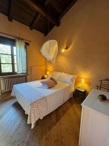 ein Schlafzimmer mit einem Bett mit einer weißen Bettdecke in der Unterkunft Villa Natura Piemonte with pool in Castino