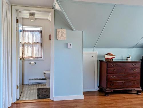 a bathroom with a sink and a toilet and a dresser at Beachy Watering Cove Cottage NEW in Prospect Harbor