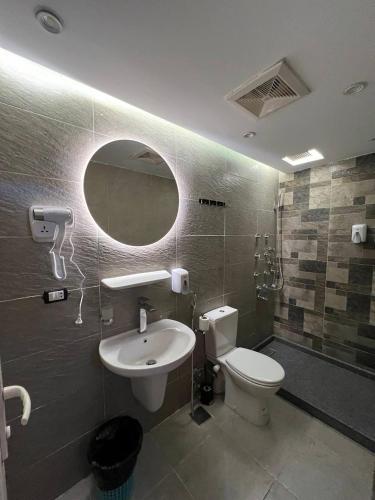 a bathroom with a sink and a toilet and a mirror at Space Hostel in Cairo