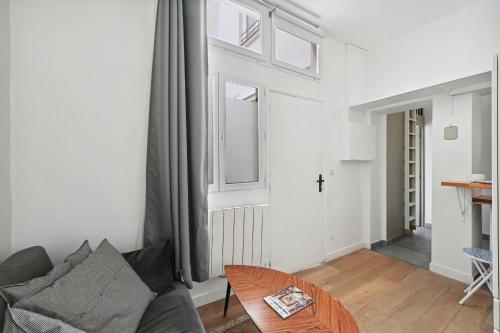 un salon avec un canapé et une table dans l'établissement Studio Denisa - Welkeys, à Paris