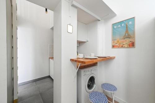 - une buanderie avec un lave-linge et des chaises bleues dans l'établissement Studio Denisa - Welkeys, à Paris