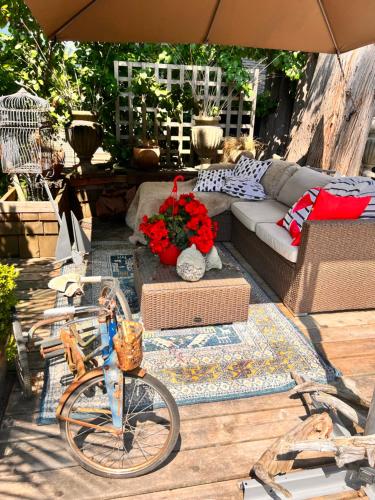 a patio with a couch and a bike on a table at PRIVATE HOUSE and private HOT TUB Seas The Day Pets BBQ Beaches Artists Studio Lower Gibsons The Bay in Gibsons